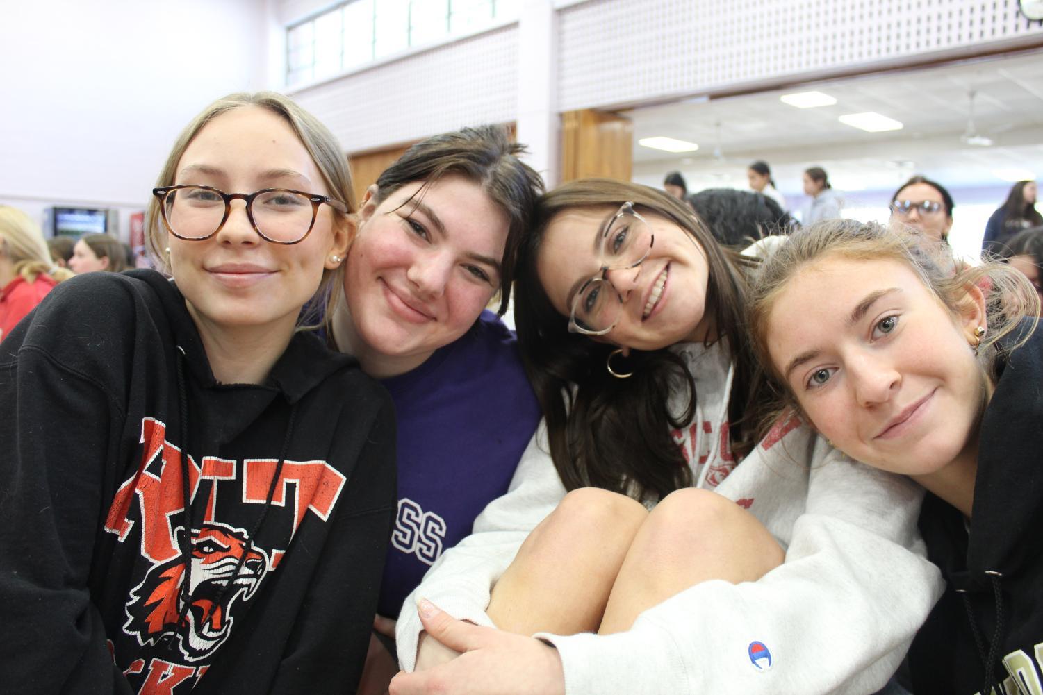 Juniors Clare Martin, Charlotte Kinsley, Sophia Massaro, and Anna Giacomini  sporting their college sweatshirts.
