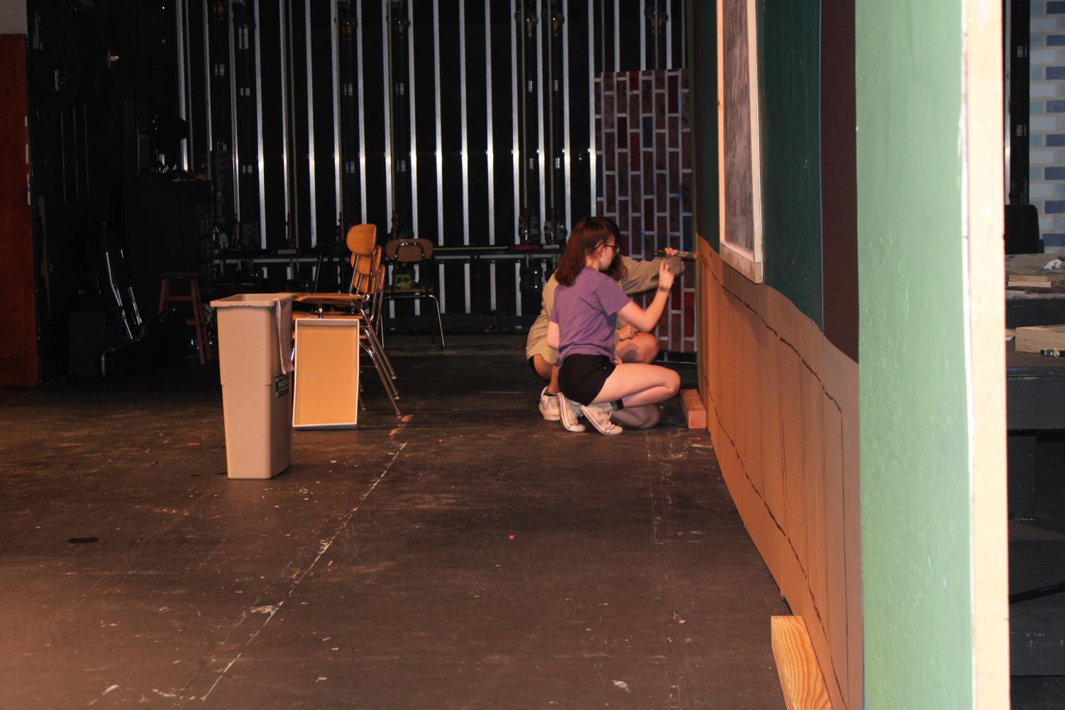 Seniors Emma Allan and Maddie Beins paint sets for the upcoming "School of Rock" production.