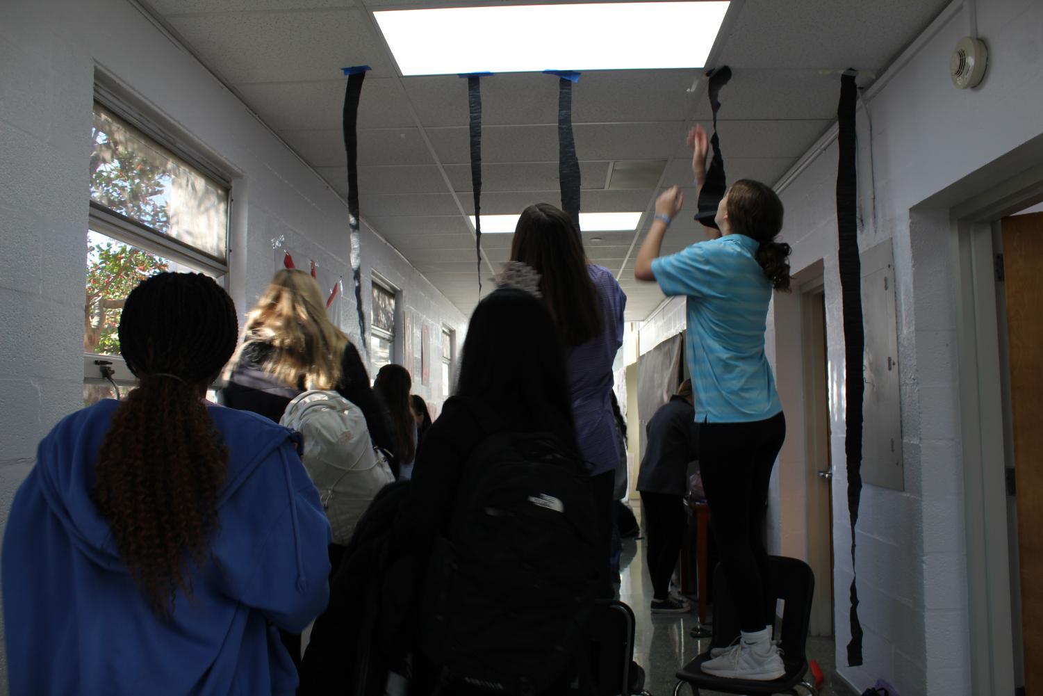 Freshmen hanging streamers in the freshman hallway.