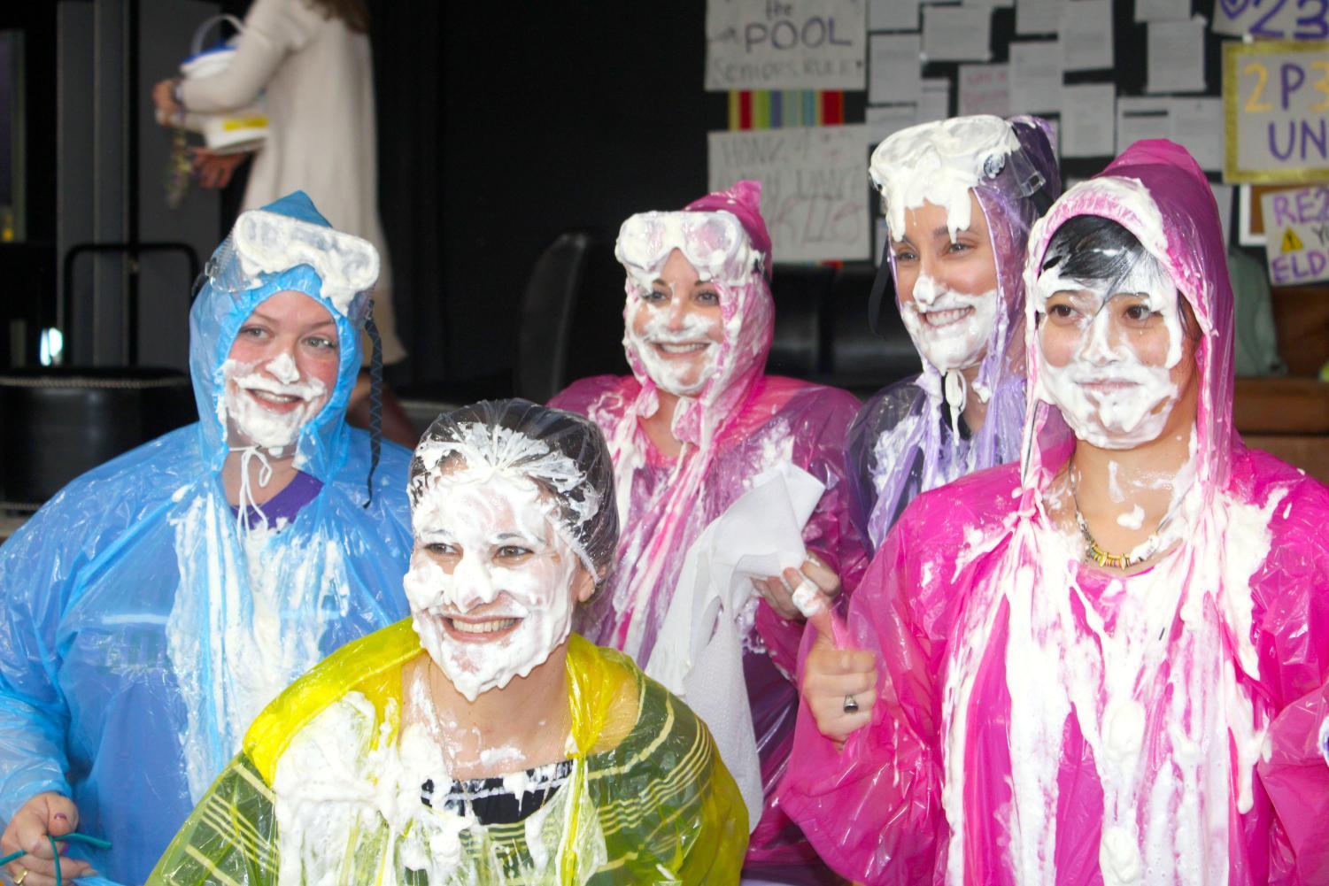 Teachers posing for a picture after being pied.