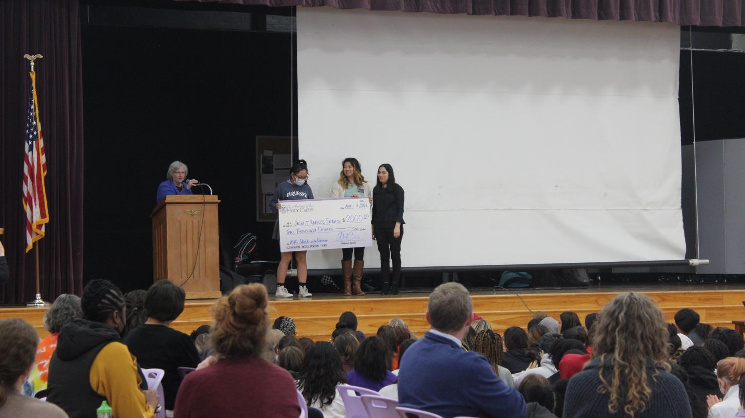 Ms. Prebble presenting a check to the Jesuit Refugee Service. The check was 2000 dollars that was raised during the Tartans for Ukraine week.