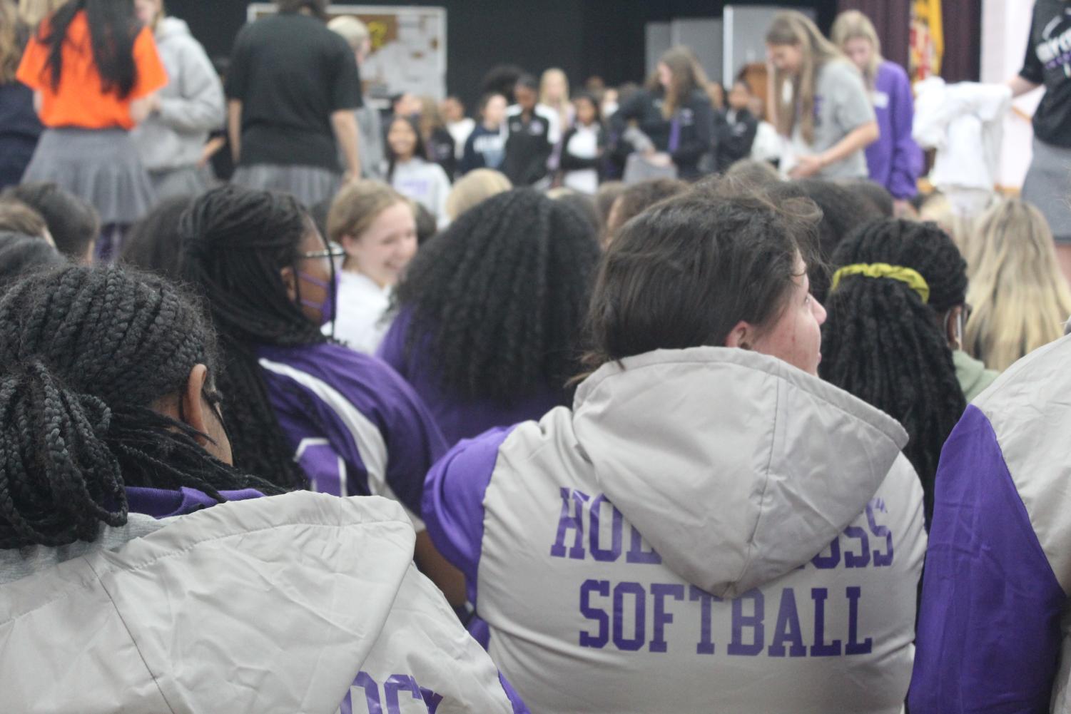 Varsity softball team watches as other teams are announce at the pep rally.