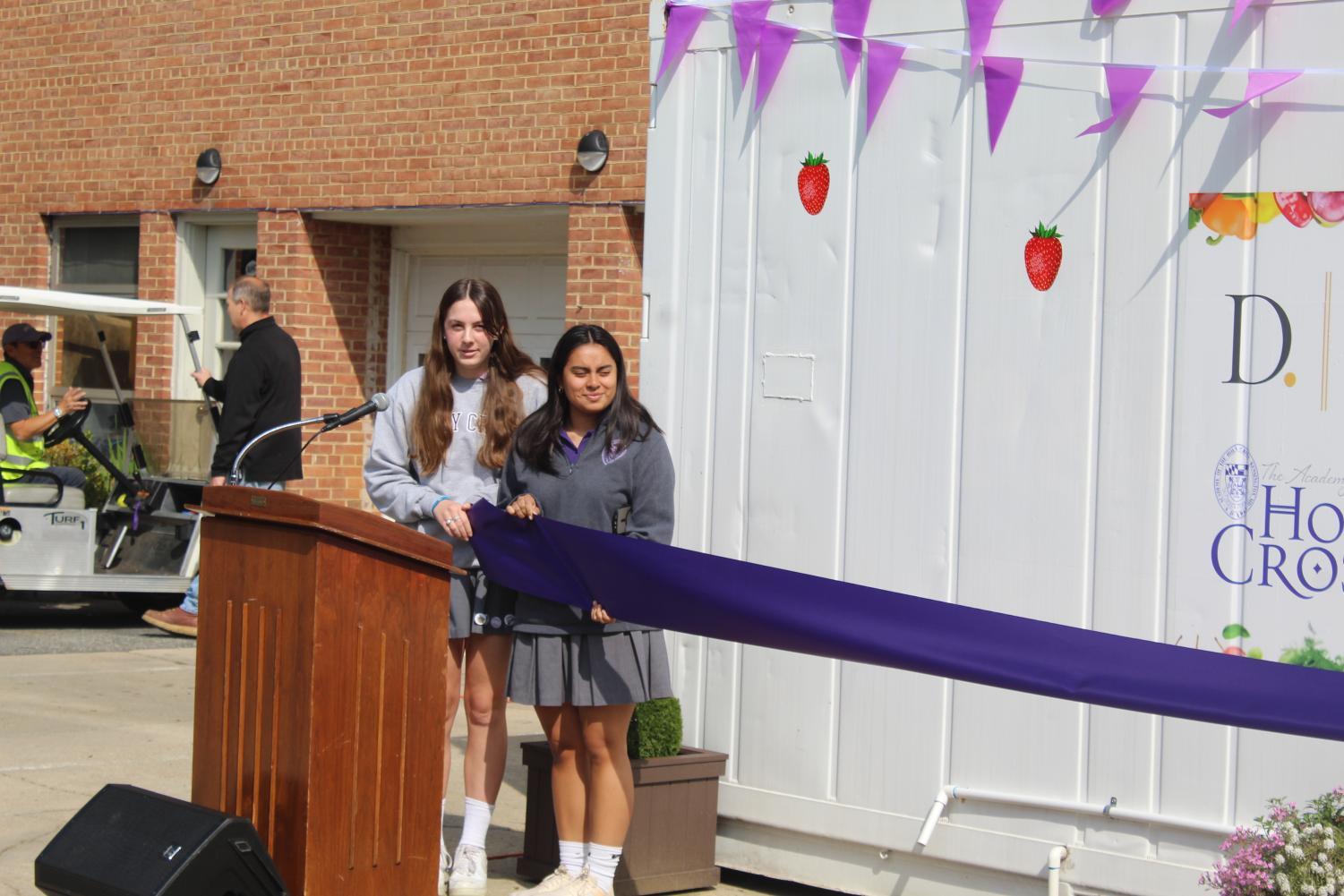 Students Gaby Lopez and Abby Sloan hold the ribbon for the CropBox cutting.