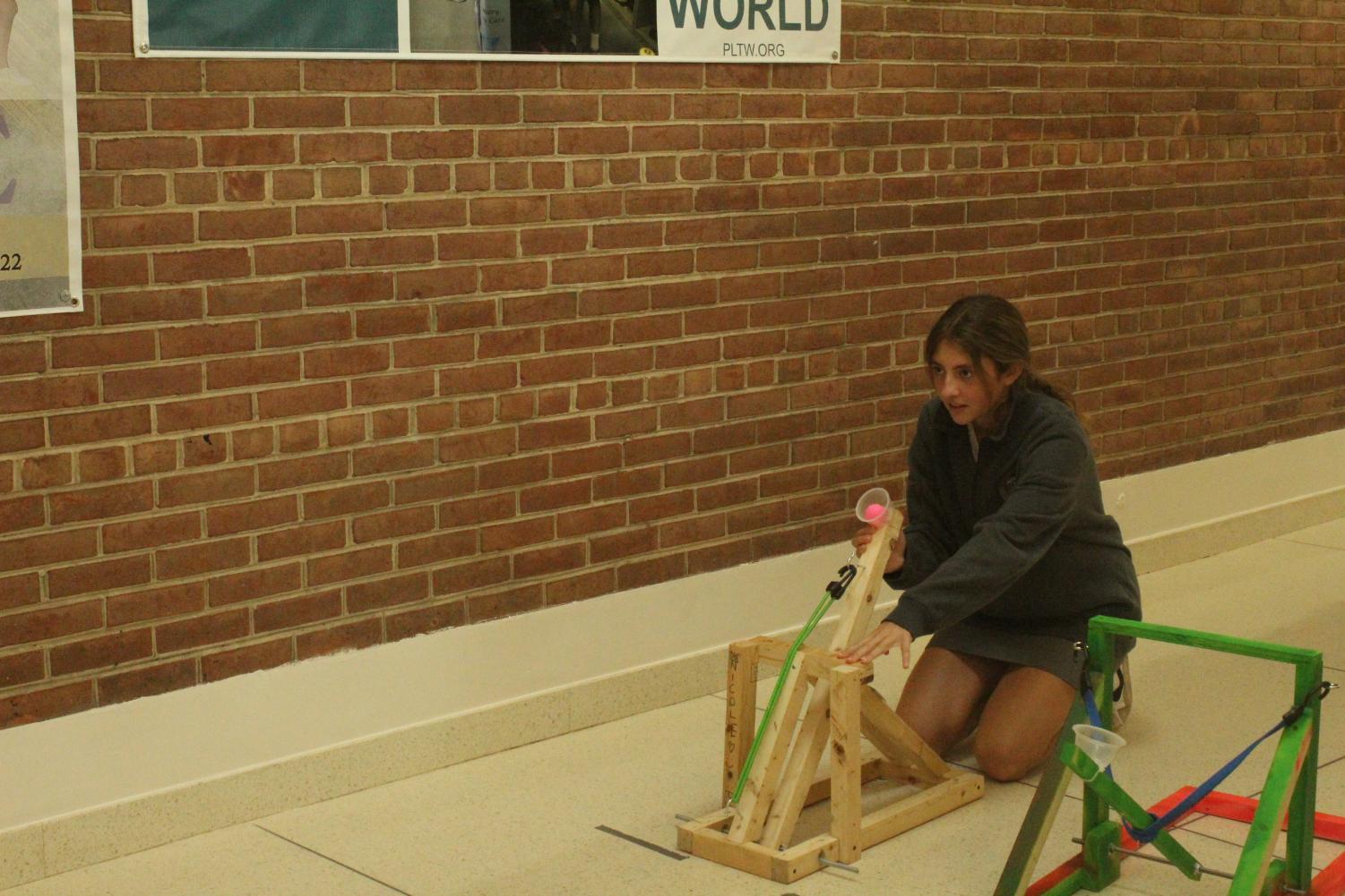 Freshman Avery Fisher works on her IED catapult project.