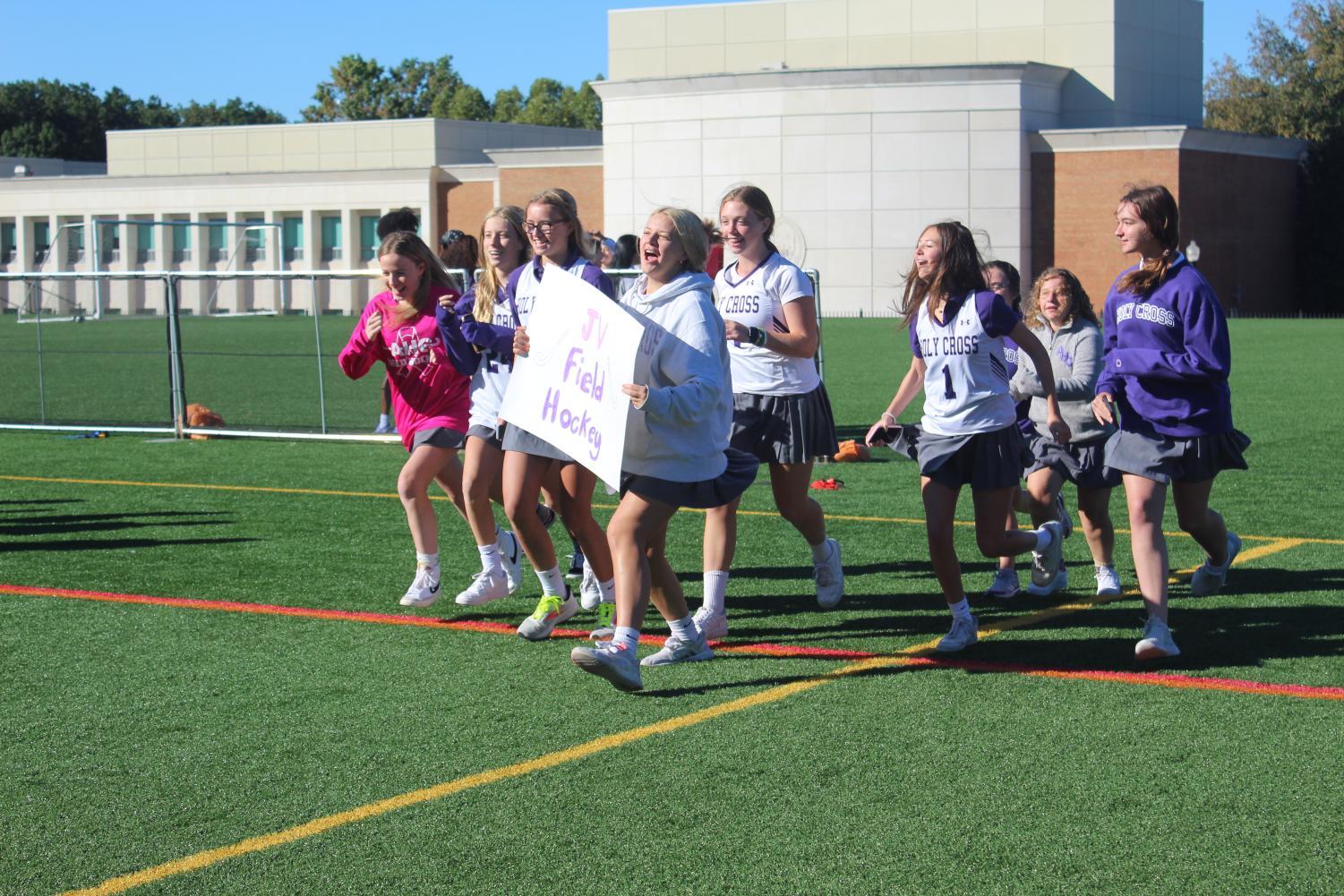 The JV field hockey team makes their entrance onto the field during the pep rally.