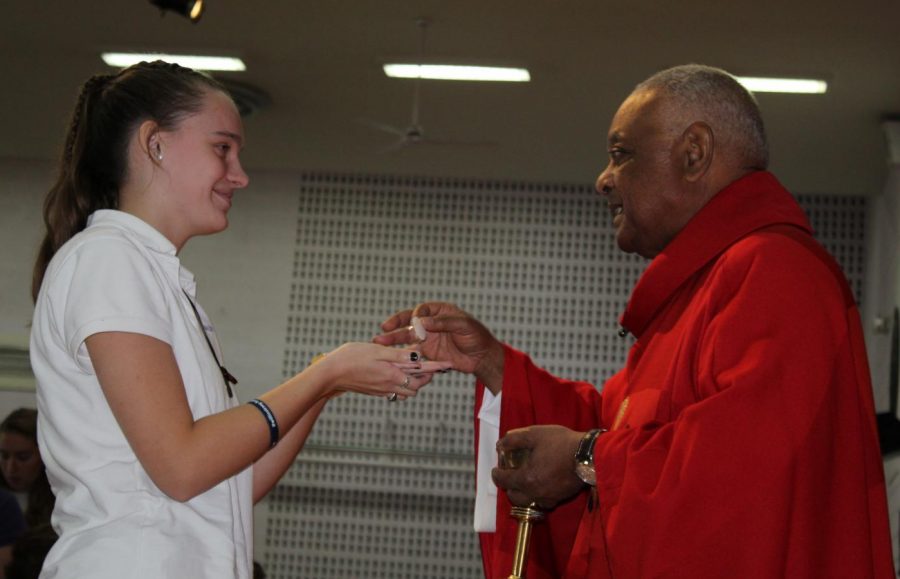 LOTA Molly Kueter 21 receiving the Eucharist from Bishop Gregory