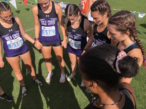 The XC team huddle and prayer before the start of their first meet
