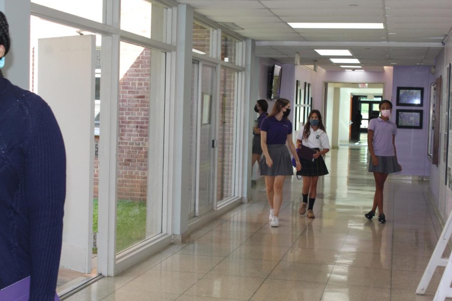 Holy Cross student walks with her shadow to the student commons after a long day of school.