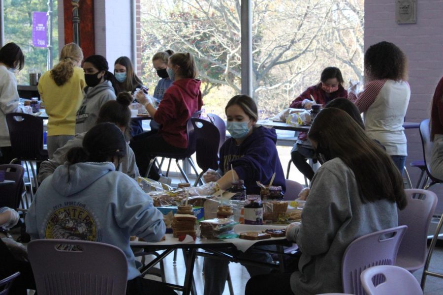 Students in the cafeteria making peanut butter and jelly sandwiches for Holy Cross Gives Thanks