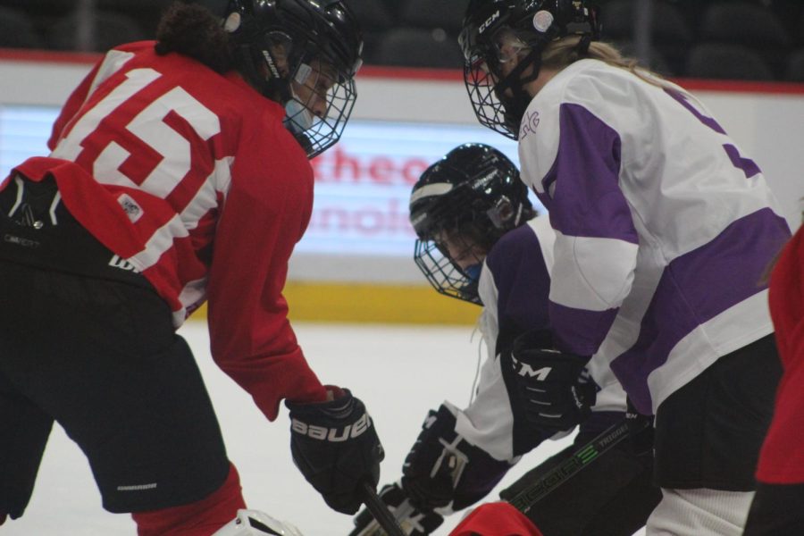 three players seen fighting for the puck