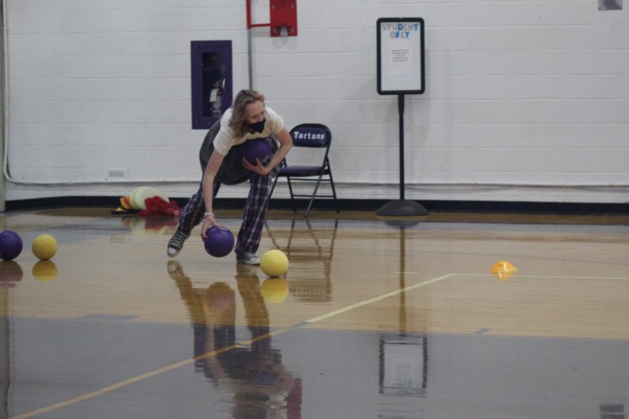 Sophomore Natalie Selden picking up balls