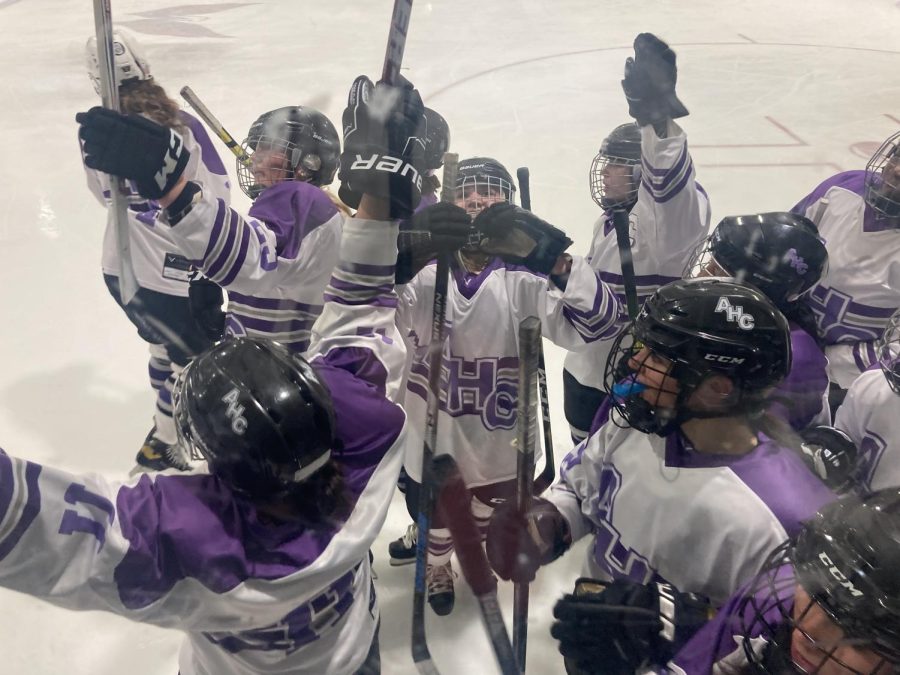 Holy Cross varsity ice hockey sings the alma mater on the ice after the championship game. Junior Jillian Puglisi makes a heart with her hand facing the camera.