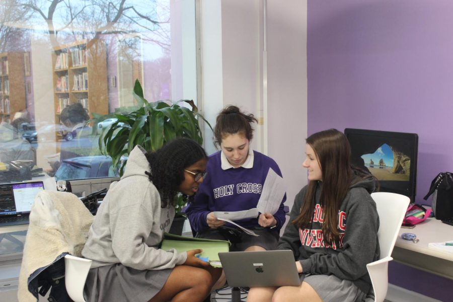 Three+people+sitting+together+in+the+library.