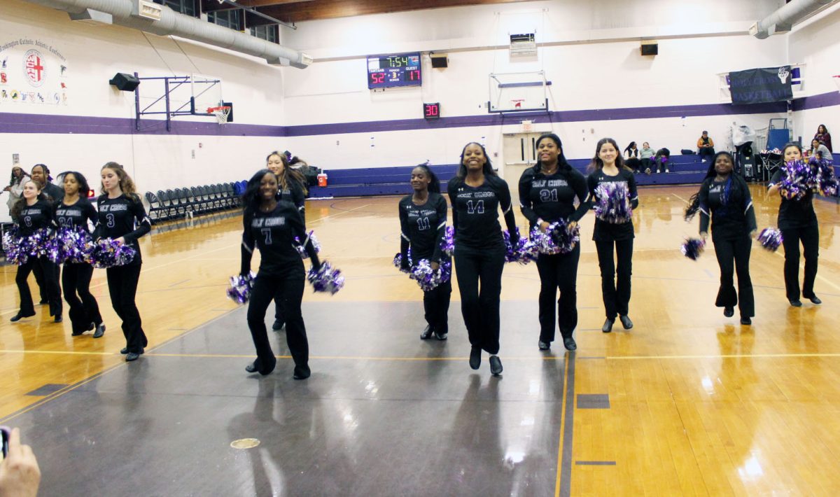 Varsity poms performing during the halftime of a Holy Cross basketball game.