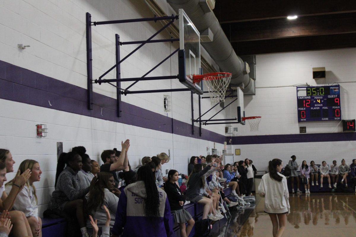 Students celebrating after a made basket during the tartan time basketball game. 